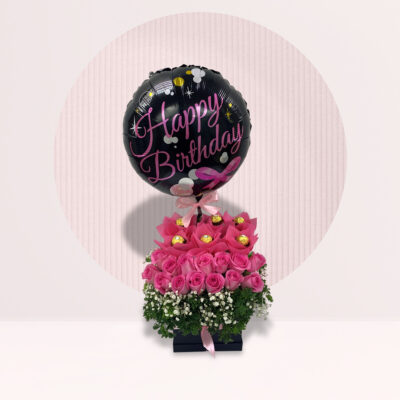 Happy Birthday wishes on a round pink rosette with colourful striped ribbons  with a gift of a bouquet of natural fresh pink tulips for a loved one or  sweetheart on her birthday