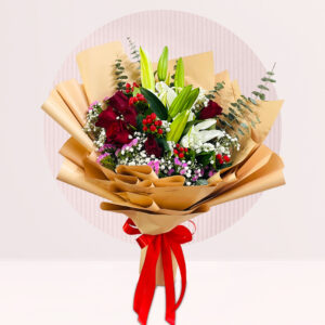A beautifully arranged bouquet is presented against a light, circular patterned background. The bouquet features a mix of dark red roses, white lilies, small purple and white flowers, and green sprigs.