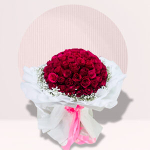 A lush, rounded bouquet of deep red roses is presented against a light-colored background with a semi-circular design. The roses are tightly packed, forming a dense, dome-shaped arrangement.