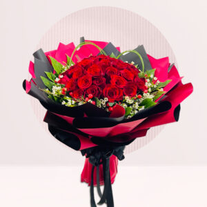 meticulously arranged bouquet of vibrant red roses, accented with small white flowers and green leaves, wrapped in layers of black and pink paper