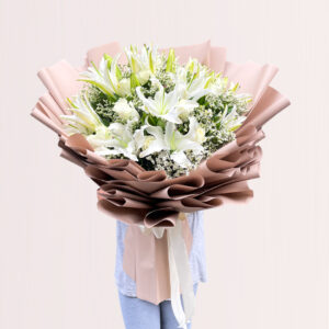 a large bouquet of white lilies wrapped in light pink paper.
