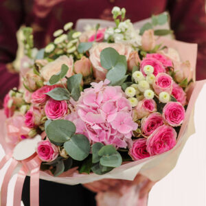 a bouquet of pink roses, hydrangeas, and other flowers.